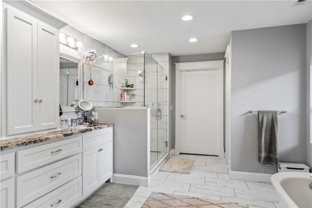3215 Windsor Ave, Kansas City, MO 64123 - bathroom featuring a shower stall, vanity, marble look tiles, a freestanding bath, and recessed lighting