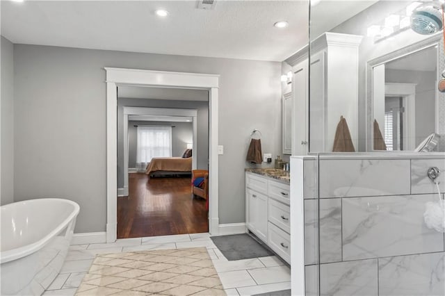 3215 Windsor Ave, Kansas City, MO 64123 - bathroom with vanity, a freestanding tub, ensuite bathroom, recessed lighting, and an enclosed shower
