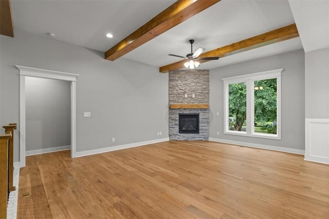 19709 W 198th Ct, Spring Hill, KS 66083 - unfurnished living room featuring beam ceiling, ceiling fan, light wood-style floors, a stone fireplace, and recessed lighting