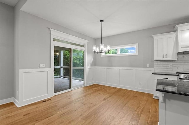 19709 W 198th Ct, Spring Hill, KS 66083 - unfurnished dining area with light wood finished floors, wainscoting, a chandelier, and a decorative wall