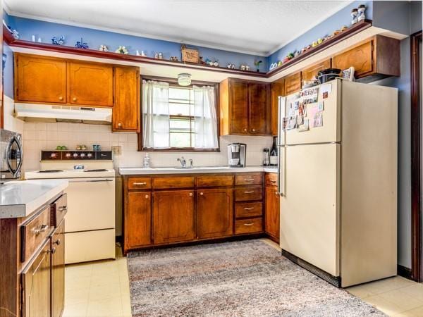 607 Green St, Lees Summit, MO 64063 - kitchen featuring white appliances, under cabinet range hood, light countertops, backsplash, and brown cabinets