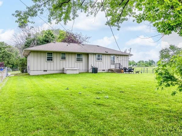607 Green St, Lees Summit, MO 64063 - rear view of property featuring board and batten siding, a fenced backyard, and entry steps