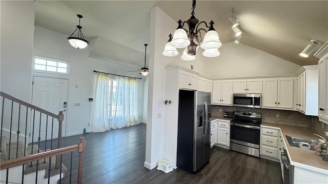 1725 N 57th Ter, Kansas City, KS 66102 - kitchen featuring stainless steel appliances, dark wood-type flooring, white cabinets, and high vaulted ceiling