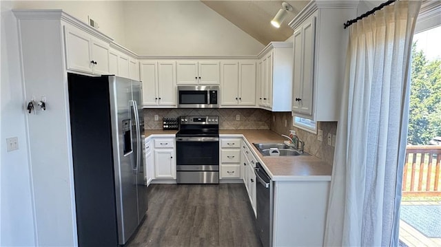 1725 N 57th Ter, Kansas City, KS 66102 - kitchen with appliances with stainless steel finishes, light countertops, lofted ceiling, decorative backsplash, and healthy amount of natural light