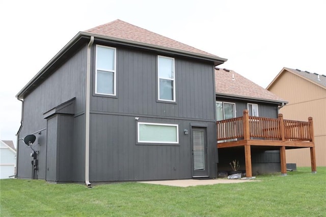 1725 N 57th Ter, Kansas City, KS 66102 - back of property with a shingled roof, a wooden deck, and a yard