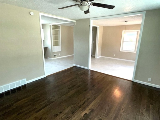 2017 E 83rd Ter, Kansas City, MO 64132 - empty room with a textured ceiling, ceiling fan, wood finished floors, and built in shelves