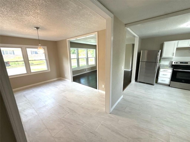2017 E 83rd Ter, Kansas City, MO 64132 - kitchen with stainless steel appliances, white cabinetry, a textured ceiling, hanging light fixtures, and light countertops