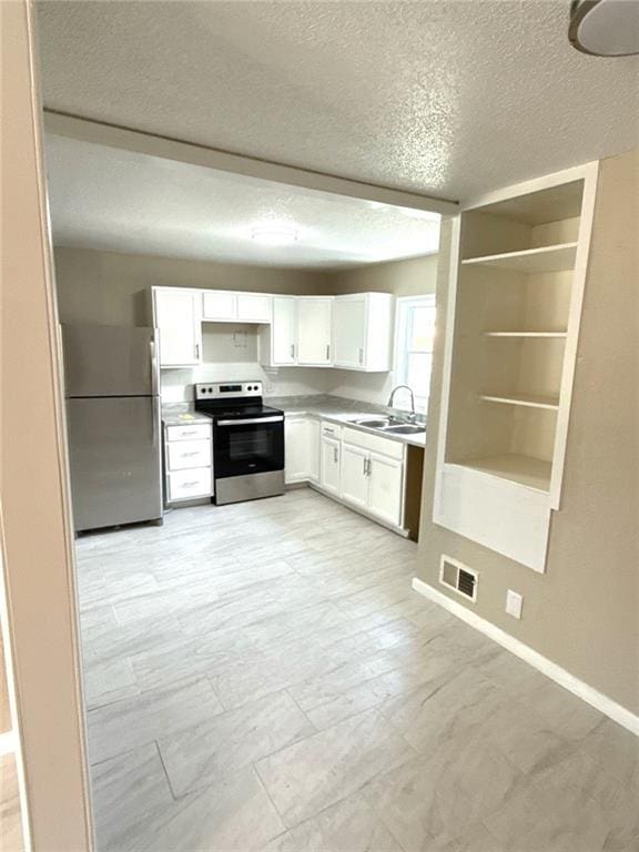 2017 E 83rd Ter, Kansas City, MO 64132 - kitchen featuring stainless steel appliances, white cabinets, a textured ceiling, light countertops, and open shelves