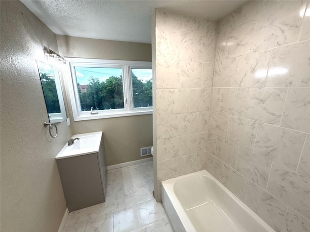 2017 E 83rd Ter, Kansas City, MO 64132 - bathroom featuring vanity, marble finish floors, a textured ceiling, and washtub / shower combination