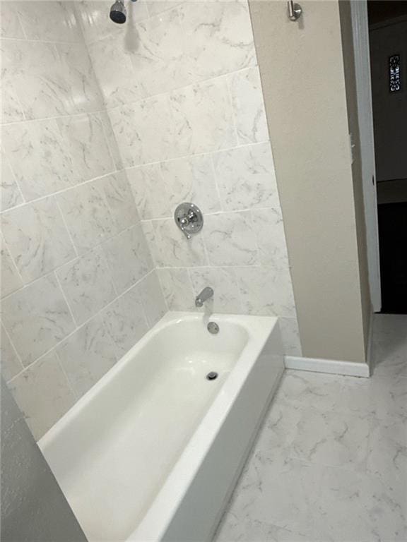2017 E 83rd Ter, Kansas City, MO 64132 - bathroom with bathtub / shower combination and marble look tiles