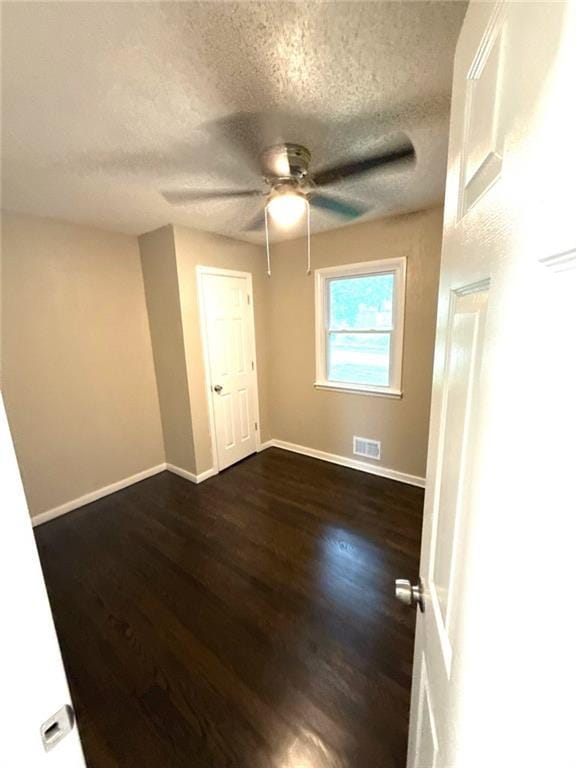 2017 E 83rd Ter, Kansas City, MO 64132 - empty room featuring a ceiling fan, dark wood-style flooring, and a textured ceiling