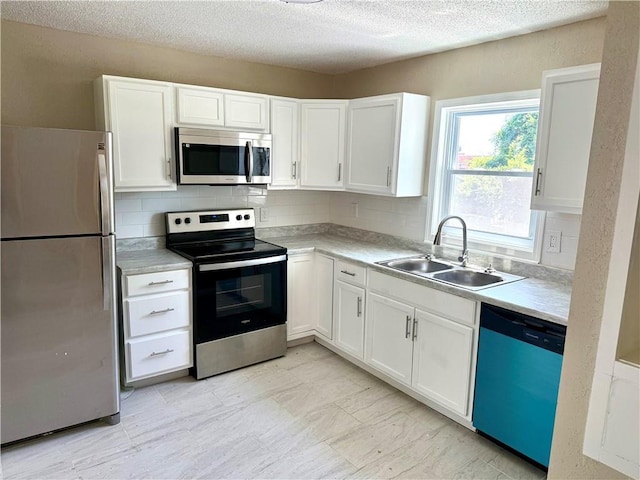 2017 E 83rd Ter, Kansas City, MO 64132 - kitchen featuring stainless steel appliances, backsplash, white cabinetry, and a textured ceiling