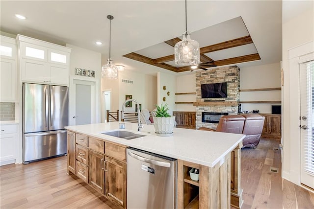 12750 Larkspur Ln, Platte City, MO 64079 - kitchen featuring stainless steel appliances, a fireplace, coffered ceiling, light wood finished floors, and ceiling fan