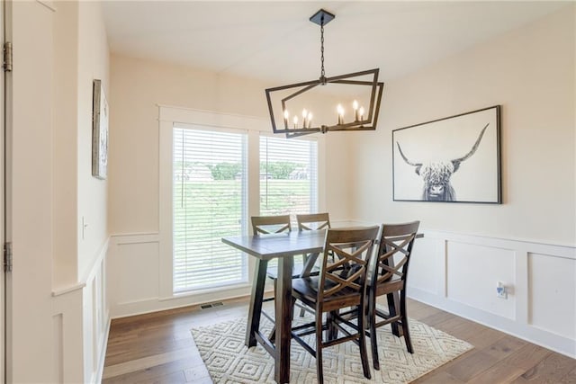 12750 Larkspur Ln, Platte City, MO 64079 - dining area with a decorative wall, wood-type flooring, a chandelier, and wainscoting