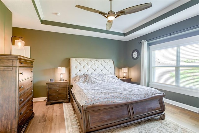 12750 Larkspur Ln, Platte City, MO 64079 - bedroom featuring a tray ceiling, light wood-type flooring, and ceiling fan