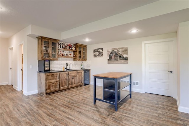 12750 Larkspur Ln, Platte City, MO 64079 - indoor wet bar with wood finished floors, dishwasher, decorative backsplash, and recessed lighting