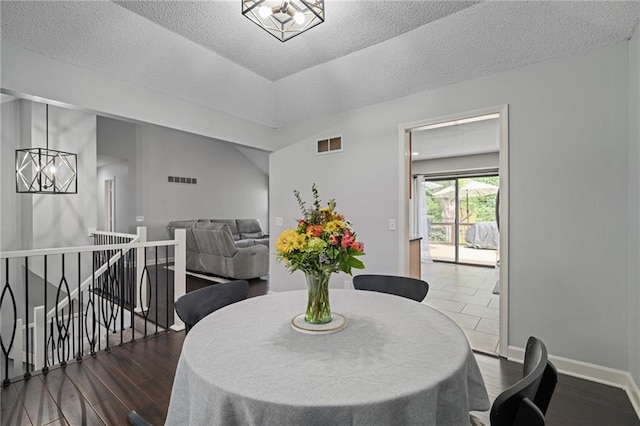 13924 S Summertree Ln, Olathe, KS 66062 - dining area with a chandelier, dark wood finished floors, and a textured ceiling