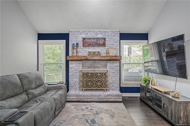 13924 S Summertree Ln, Olathe, KS 66062 - living room with lofted ceiling, a textured ceiling, dark wood-type flooring, plenty of natural light, and a brick fireplace