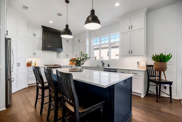 13404 W 177th St, Overland Park, KS 66013 - kitchen with dark wood-style flooring, recessed lighting, custom exhaust hood, freestanding refrigerator, and a center island