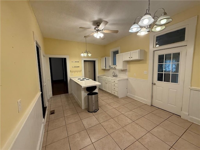 624 S St, Atchison, KS 66002 - kitchen with a chandelier, light tile patterned floors, light countertops, white cabinetry, and a textured ceiling