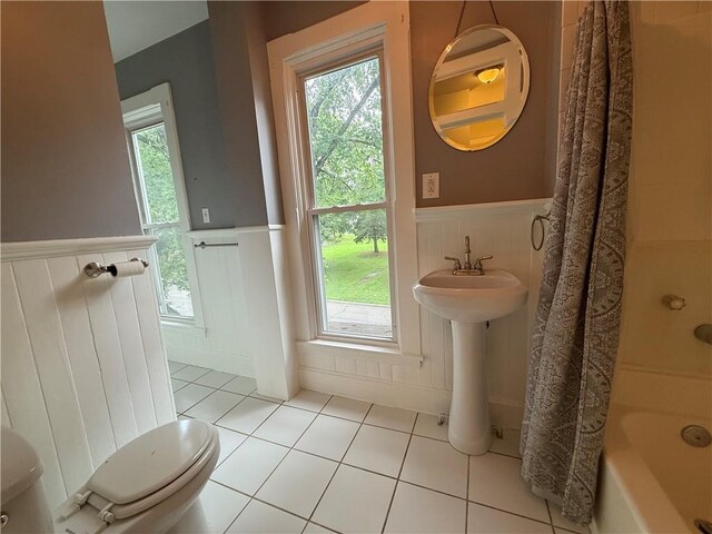 624 S St, Atchison, KS 66002 - full bathroom featuring a wainscoted wall, tile patterned floors, shower / bathtub combination with curtain, and a decorative wall
