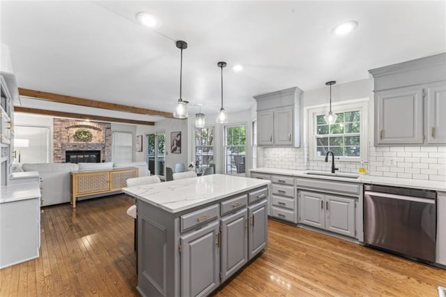 2405 W 124th St, Leawood, KS 66209 - kitchen with gray cabinets, stainless steel dishwasher, open floor plan, a center island, and backsplash