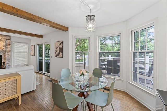 2405 W 124th St, Leawood, KS 66209 - dining space with healthy amount of natural light, wood-type flooring, a chandelier, beamed ceiling, and a fireplace