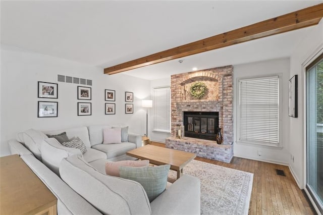 2405 W 124th St, Leawood, KS 66209 - living room with beamed ceiling, a brick fireplace, and hardwood / wood-style flooring