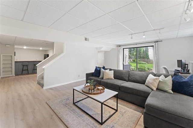2405 W 124th St, Leawood, KS 66209 - living room with a paneled ceiling, rail lighting, stairway, and light wood-style floors
