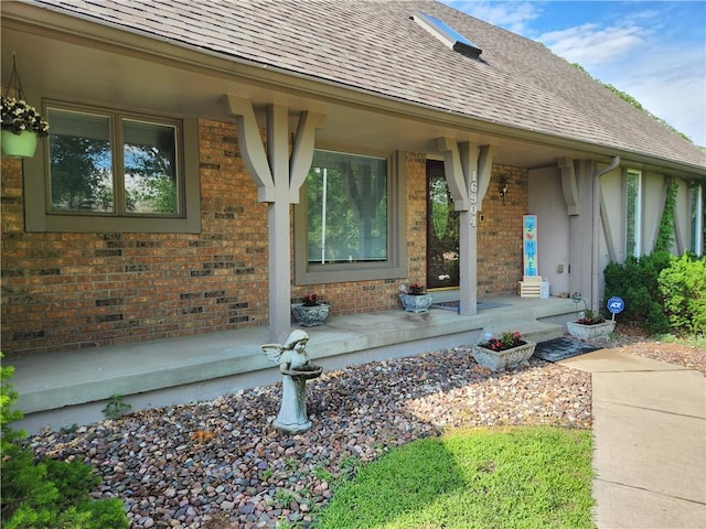 16904 E 36th St S, Independence, MO 64055 - entrance to property featuring brick siding, roof with shingles, and covered porch