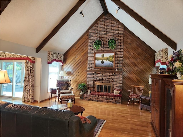 16904 E 36th St S, Independence, MO 64055 - living room with beam ceiling, wood walls, a fireplace, wood finished floors, and high vaulted ceiling
