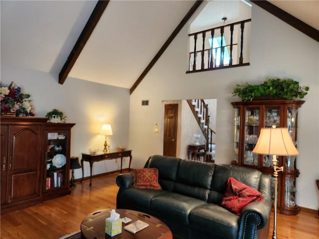 16904 E 36th St S, Independence, MO 64055 - living room featuring stairs, wood finished floors, high vaulted ceiling, and beam ceiling