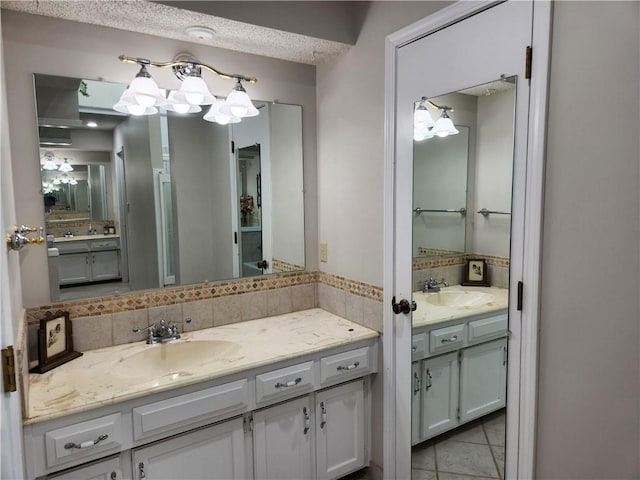 16904 E 36th St S, Independence, MO 64055 - full bathroom featuring two vanities, decorative backsplash, tile patterned floors, and a chandelier