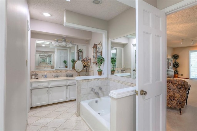 16904 E 36th St S, Independence, MO 64055 - bathroom with a textured ceiling, a garden tub, vanity, decorative backsplash, and tile patterned floors