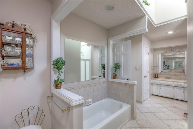 16904 E 36th St S, Independence, MO 64055 - bathroom featuring a garden tub, a textured ceiling, vanity, and tile patterned floors