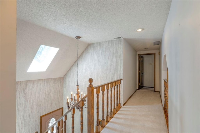 16904 E 36th St S, Independence, MO 64055 - hallway featuring wallpapered walls, a skylight, a chandelier, a textured ceiling, and carpet