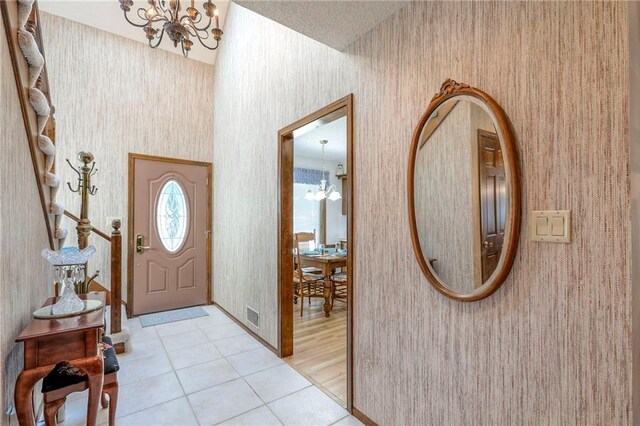 16904 E 36th St S, Independence, MO 64055 - entryway featuring a chandelier, wallpapered walls, and light tile patterned floors