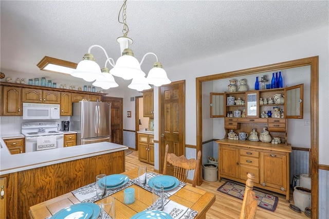 16904 E 36th St S, Independence, MO 64055 - dining room with a chandelier, light wood finished floors, and a textured ceiling