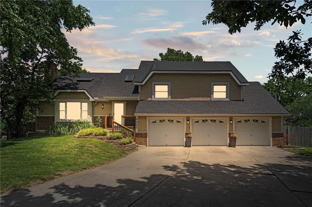 4402 NW 65th Ct, Kansas City, MO 64151 - split level home with brick siding, concrete driveway, an attached garage, and stucco siding
