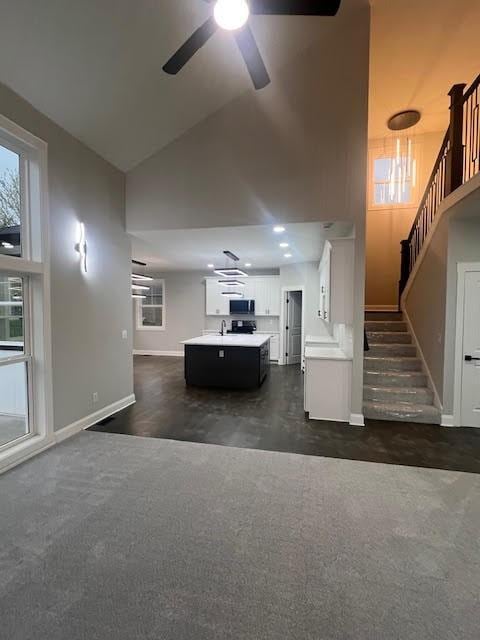 26433 W 144th Ter, Olathe, KS 66061 - living room featuring ceiling fan, stairway, high vaulted ceiling, and dark carpet