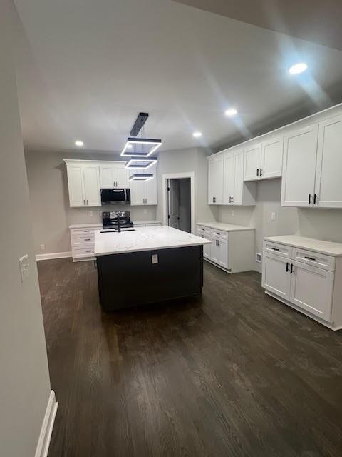 26433 W 144th Ter, Olathe, KS 66061 - kitchen featuring stainless steel microwave, dark wood-style flooring, white cabinets, recessed lighting, and light countertops