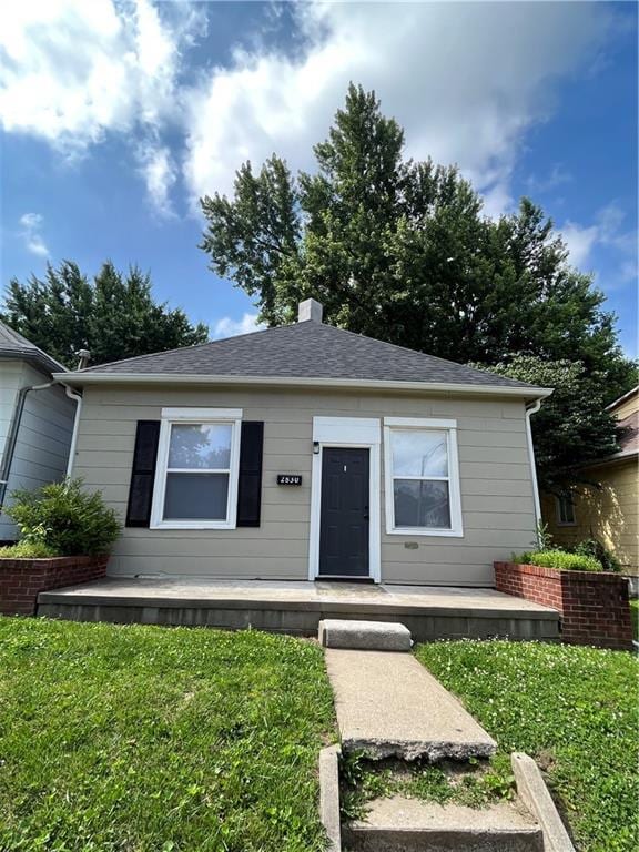 2830 Jules St, Saint Joseph, MO 64501 - view of front of home featuring a front lawn, a chimney, roof with shingles, and a porch