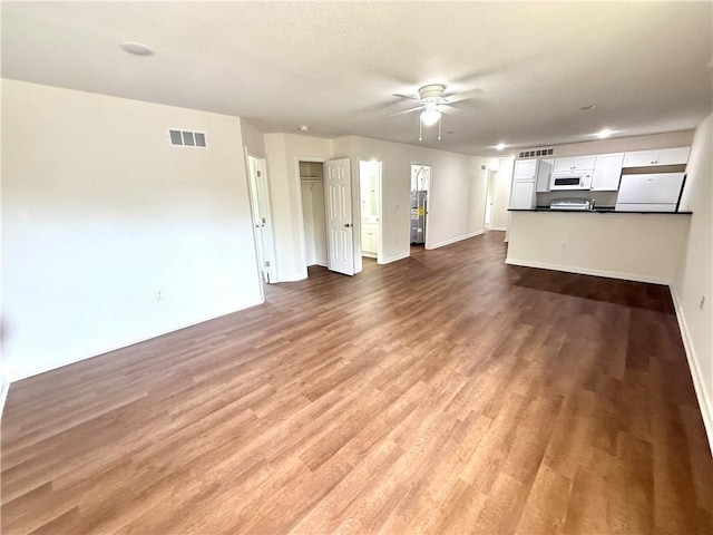 719 E Culton St, Warrensburg, MO 64093 - unfurnished living room with a ceiling fan and wood finished floors