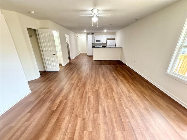 719 E Culton St, Warrensburg, MO 64093 - unfurnished living room with dark wood-style floors and a ceiling fan