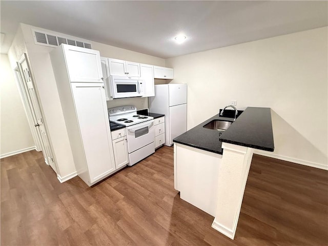 719 E Culton St, Warrensburg, MO 64093 - kitchen featuring white appliances, wood finished floors, white cabinetry, and a peninsula