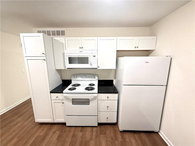 719 E Culton St, Warrensburg, MO 64093 - kitchen featuring white appliances, white cabinetry, dark wood finished floors, and dark countertops