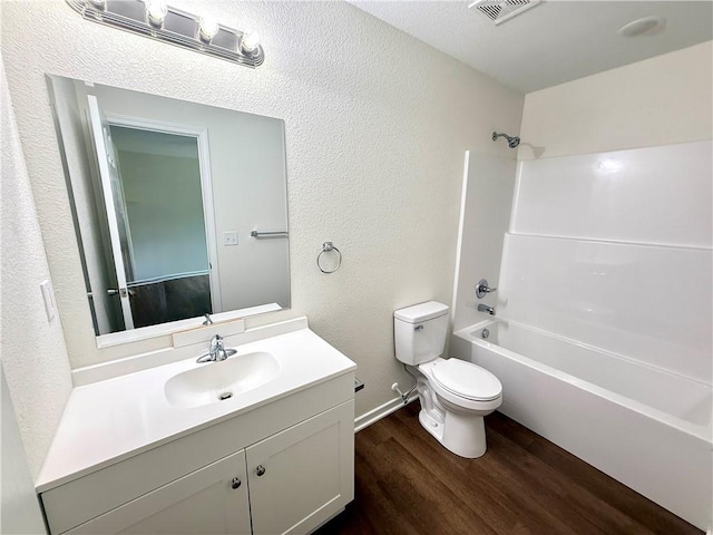 719 E Culton St, Warrensburg, MO 64093 - full bathroom featuring wood finished floors, washtub / shower combination, vanity, and a textured wall
