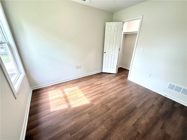 719 E Culton St, Warrensburg, MO 64093 - unfurnished bedroom featuring dark wood finished floors and a spacious closet