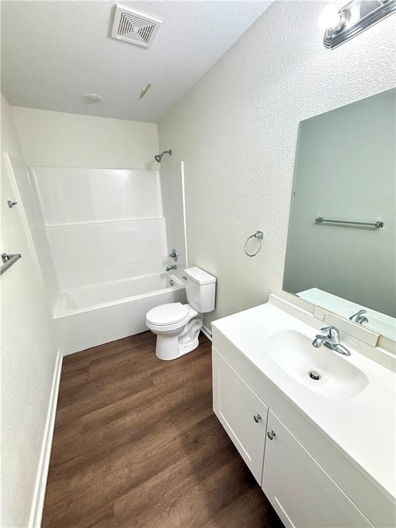 719 E Culton St, Warrensburg, MO 64093 - bathroom with vanity, bathing tub / shower combination, wood finished floors, a textured wall, and a textured ceiling