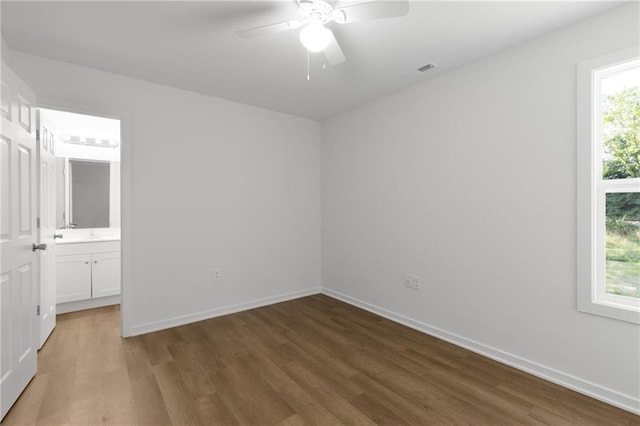 719 E Culton St, Warrensburg, MO 64093 - unfurnished bedroom with wood finished floors, connected bathroom, and a ceiling fan